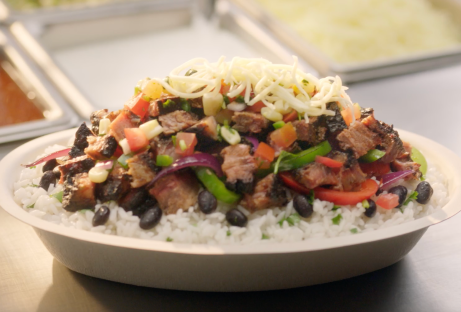 A Smoked Brisket Burrito Bowl with White Rice, Black Beans, Fajita Veggies, fresh hand-chopped Smoked Brisket, Fresh Tomato Salsa, Roasted Chili Corn Salsa, and Monterey Jack shredded cheese.